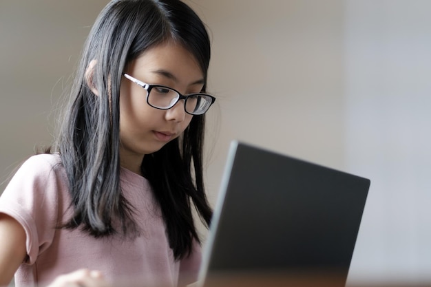 Colegiala joven que usa la computadora portátil