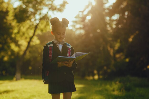 Foto colegiala lee un libro en el parque