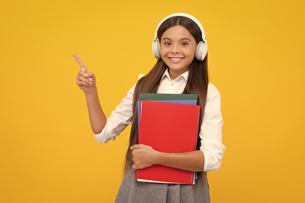 Colegiala con libro de copia posando sobre fondo aislado Lección de literatura escuela de gramática Lector infantil intelectual Niña feliz cara emociones positivas y sonrientes