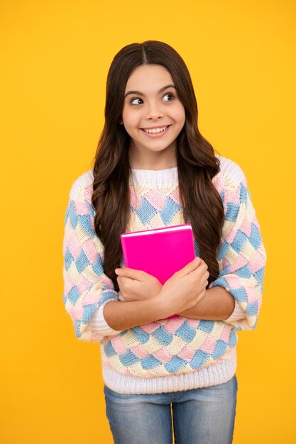 Colegiala con libro de copia posando sobre fondo aislado Lección de literatura escuela de gramática Lector infantil intelectual