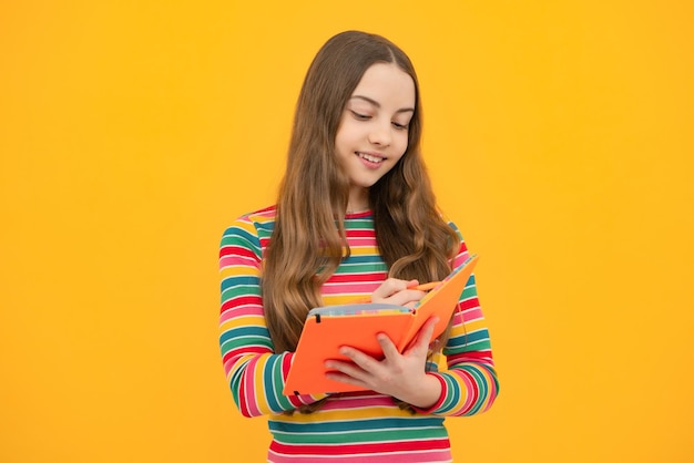 Colegiala con libro de copia posando sobre fondo aislado Lección de literatura escuela de gramática Lector infantil intelectual