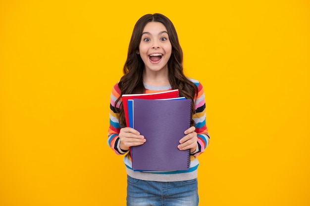 Colegiala con libro de copia posando sobre fondo aislado Lección de literatura escuela de gramática Lector de niños intelectuales Adolescente feliz emociones positivas y sonrientes de niña adolescente