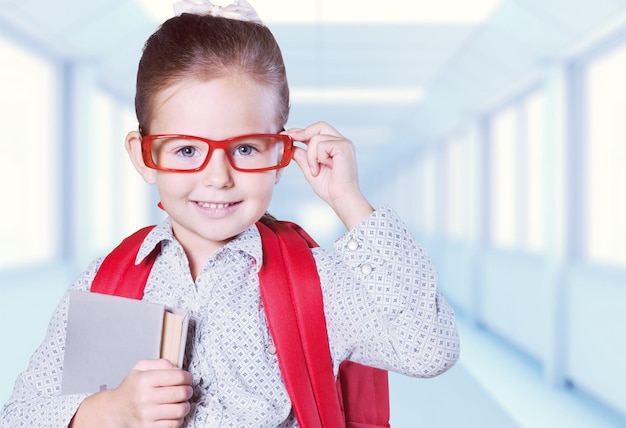 Colegiala con libro sobre fondo de pizarra