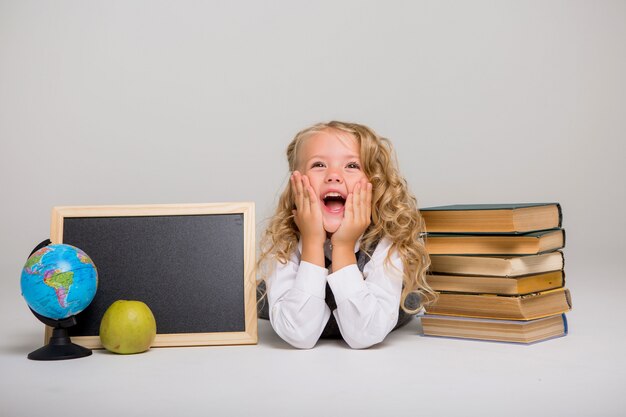 colegiala con libros sobre un fondo claro