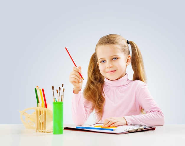 Una colegiala en la mesa hace la tarea