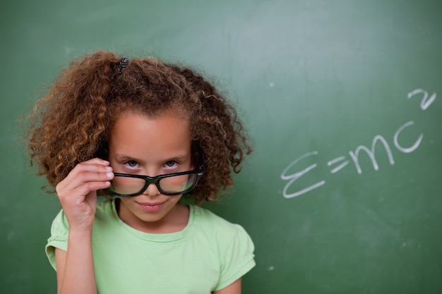 Colegiala mirando por encima de sus gafas