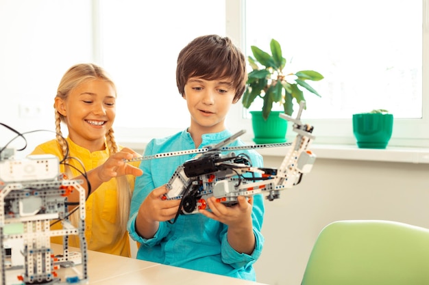 Colegiala mirando el helicóptero hecho por su compañero de clase