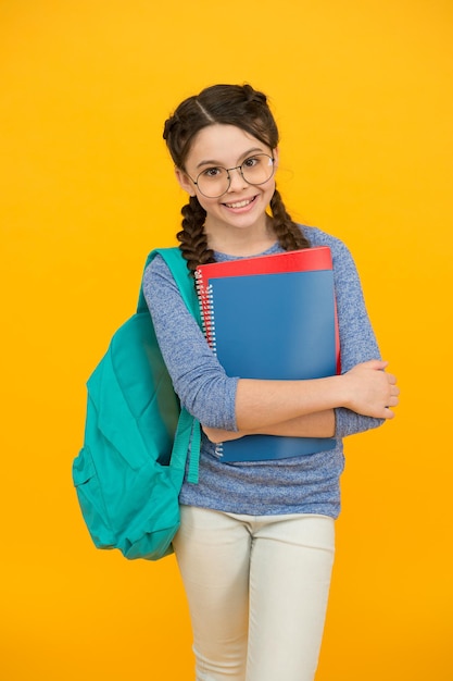 Colegiala niña estudiando activamente y logrando el concepto de lecciones escolares