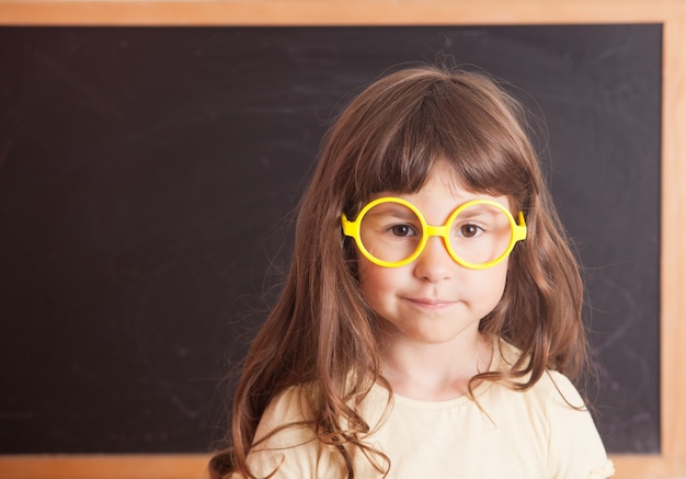 Colegiala niña feliz de la pizarra