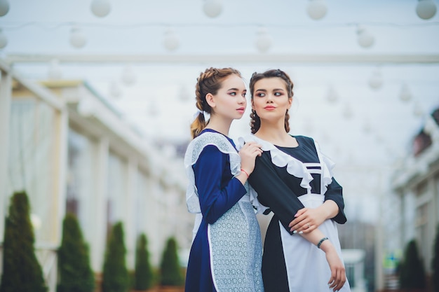 Colegiala de pie con delantal uniforme azul marino típico