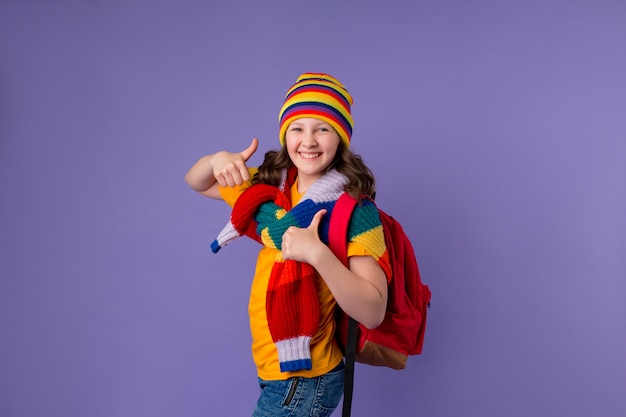 Colegiala sonríe con una mochila en el hombro