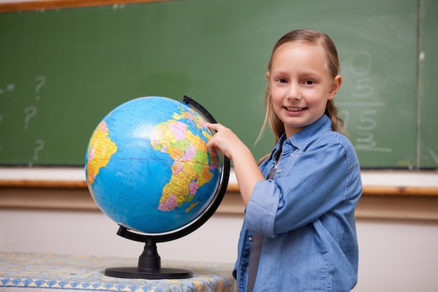 Colegiala sonriente mirando un globo