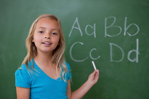 Colegiala sonriente mostrando letras