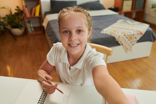 Colegiala tomando Selfie en el escritorio