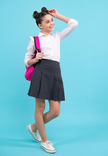 Colegiala en uniforme escolar con mochila Adolescente estudiante sobre fondo azul aislado Aprendizaje de conocimientos y concepto de educación infantil