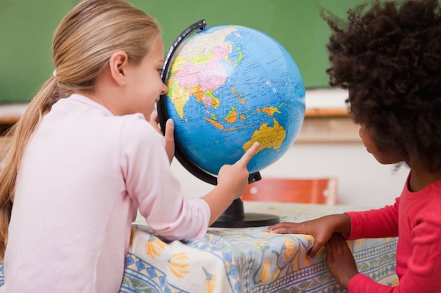 Foto colegialas pequeñas mirando un globo