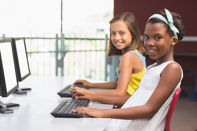 Colegialas usando la computadora en el aula