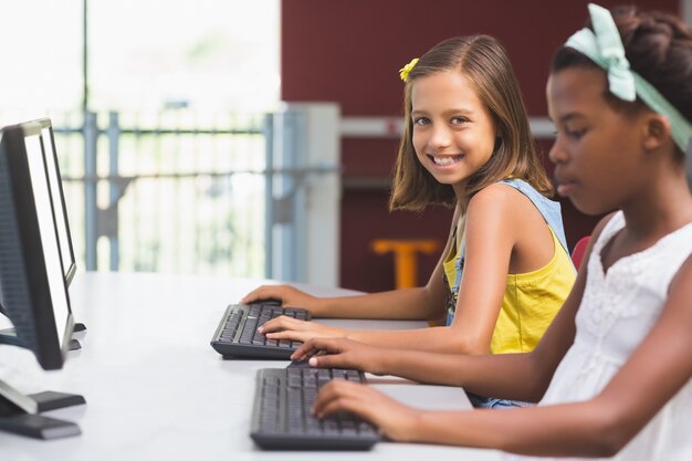 Colegialas usando la computadora en el aula