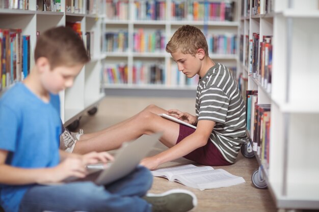 Colegiales atentos que estudian en la biblioteca