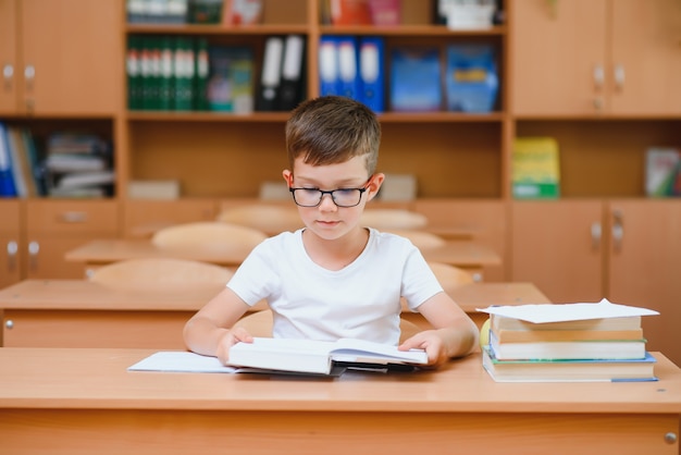 Colegiales felices sentados en el escritorio, aula