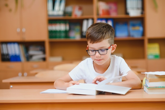 Colegiales felices sentados en el escritorio, aula