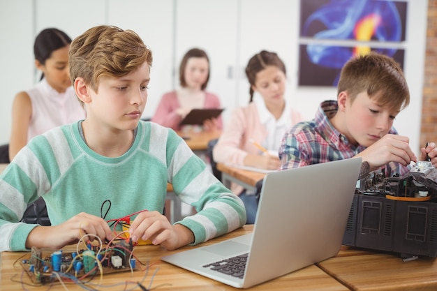 Los colegiales trabajando en un proyecto electrónico en el aula