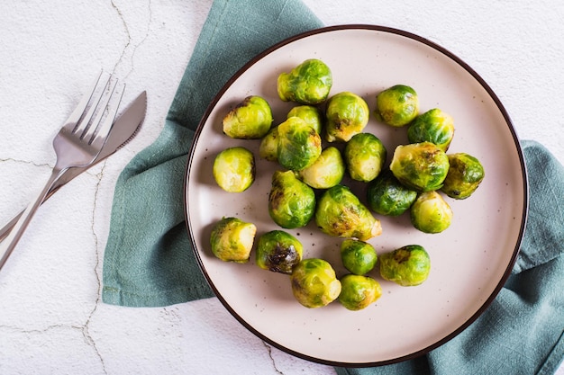 Coles de Bruselas asadas en un plato sobre la mesa Dieta vegetariana Vista superior Primer plano