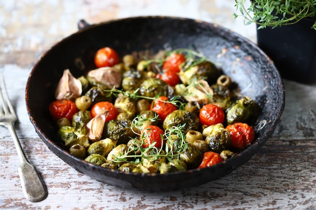 Coles de Bruselas con verduras y hierbas en una sartén