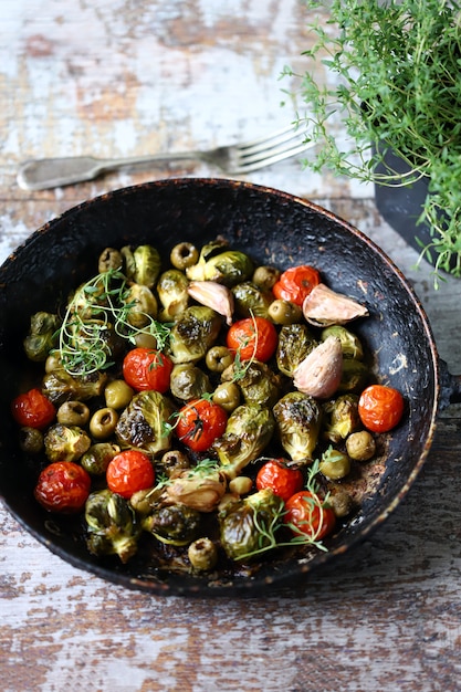 Coles de Bruselas con verduras y hierbas en una sartén