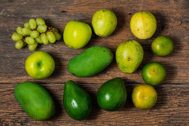 Coleta de frutas verdes isoladas em mesa de madeira