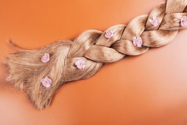 Coleta de pelo largo y rubio con flores de sakura Día Internacional del Cabello Día del Cabello Malo Espacio para copiar