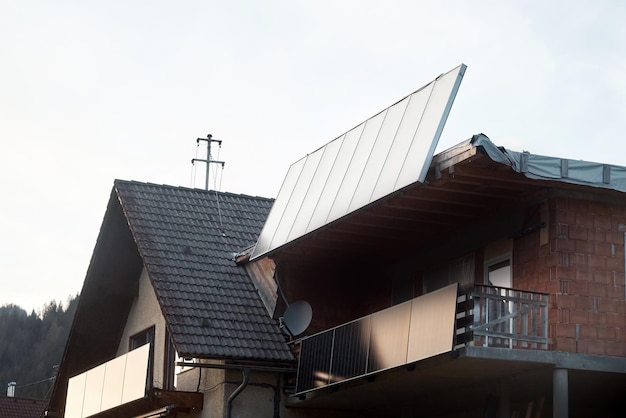 Coletor solar de água em um telhado de metal vermelho Solar térmico e painel solar para água quente