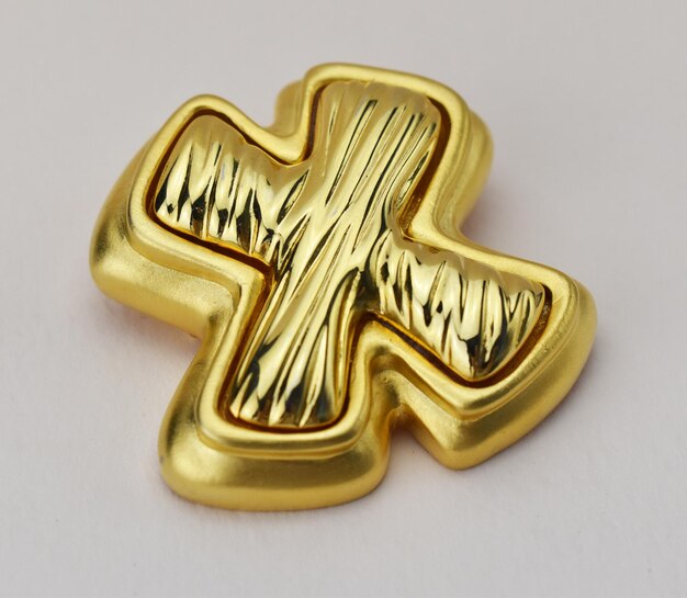 colgante de joyas en forma de cruz sobre un fondo blanco