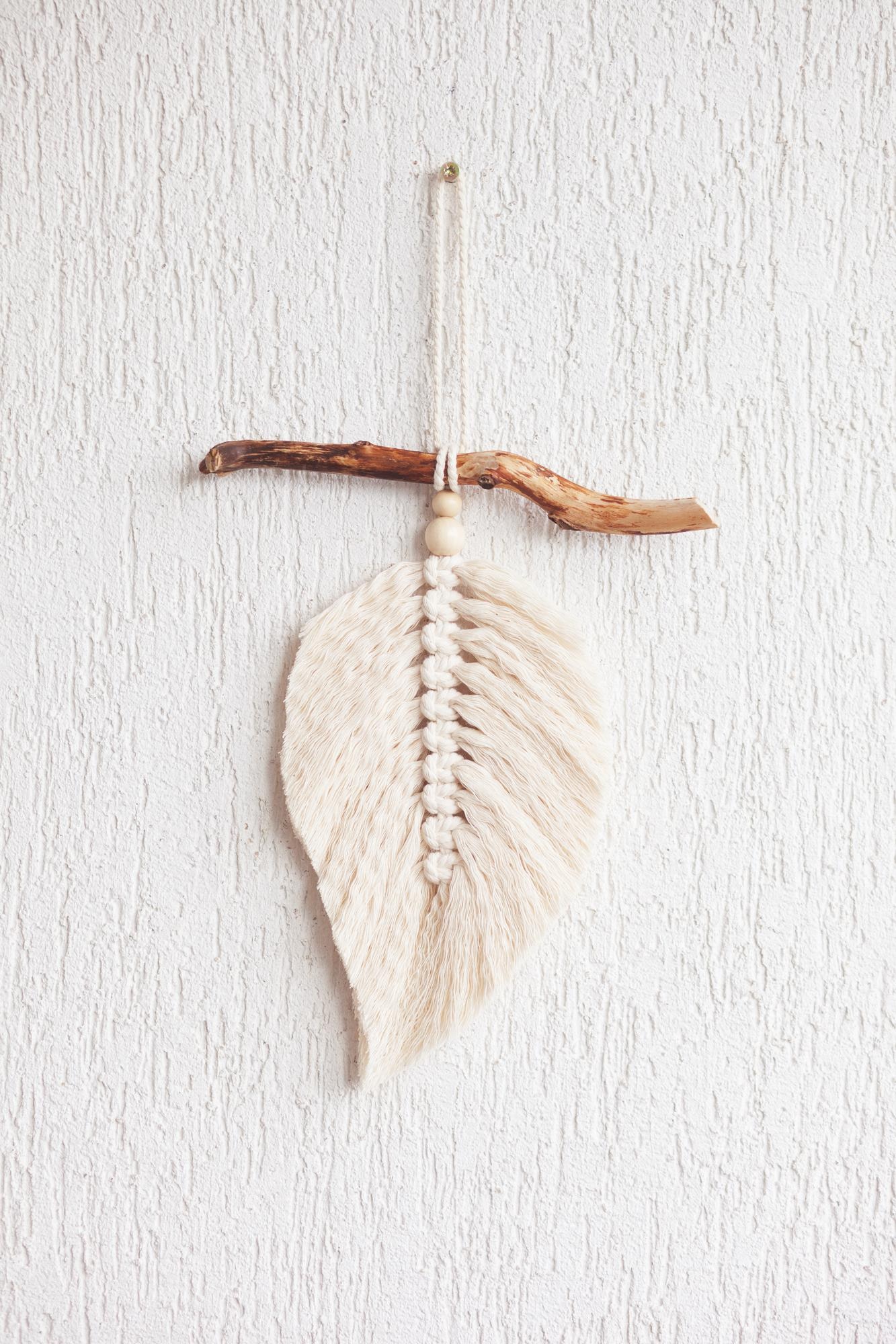 Colgante de pared hoja de macramé en color natural sobre el palo de madera. macramé de decoración de cuerda algodón para hacer tu habitación más acogedora y única. | Foto