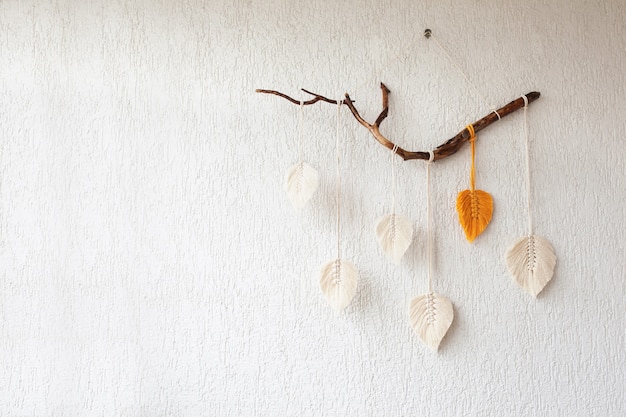 Colgante de pared de hojas de macramé en color amarillo, blanco y verde y natural en el palo de madera. Macramé de decoración de cuerda de algodón para hacer que tu habitación sea más acogedora y única. Copia espacio