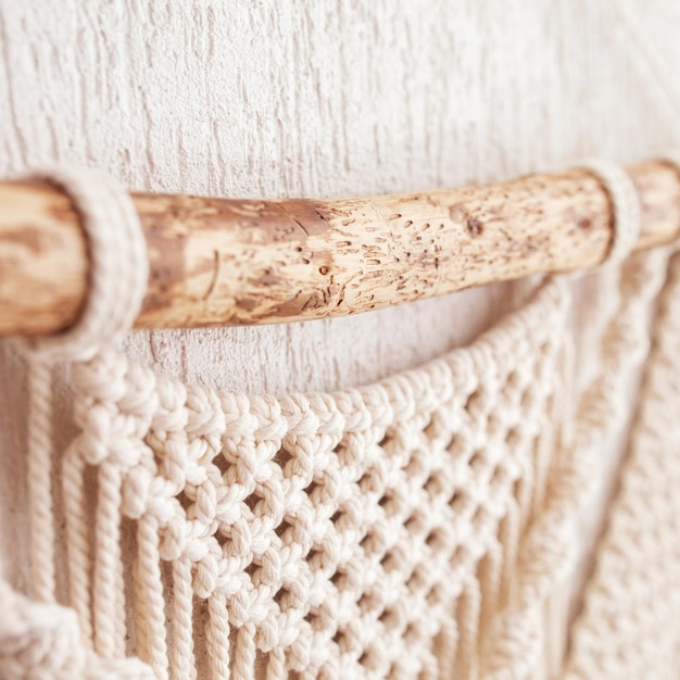 Colgante de pared de macramé hecho a mano Palo de madera con decoración de pared de algodón 100 Trenzado de macramé e hilos de algodón Pasatiempo femenino Concepto moderno y ecológico en el interior