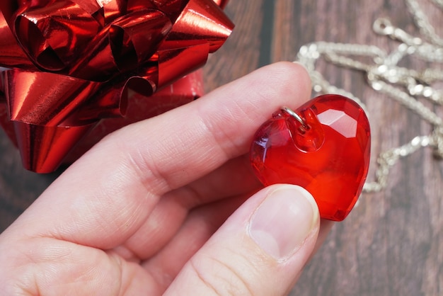 Colgante de rubí rojo como corazón en primer plano de la mano