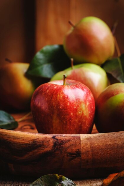 Colheita de maçãs verdes vermelhas no fundo de madeira vintage