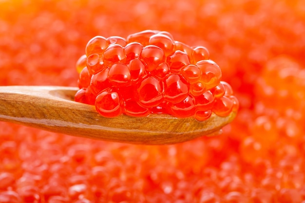 Colher com caviar vermelho sobre ovas turva