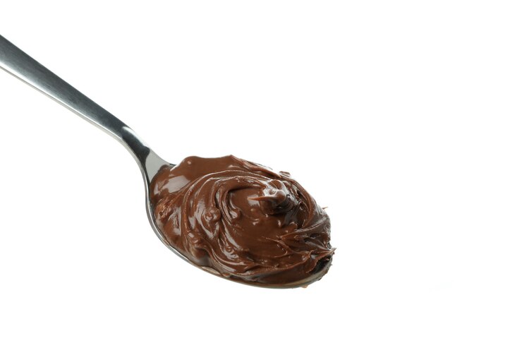 Foto colher com pasta de chocolate isolada no fundo branco
