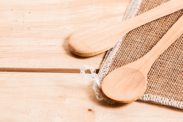 Foto colher de madeira, colocar no saco e mesa de madeira background na cozinha caseira