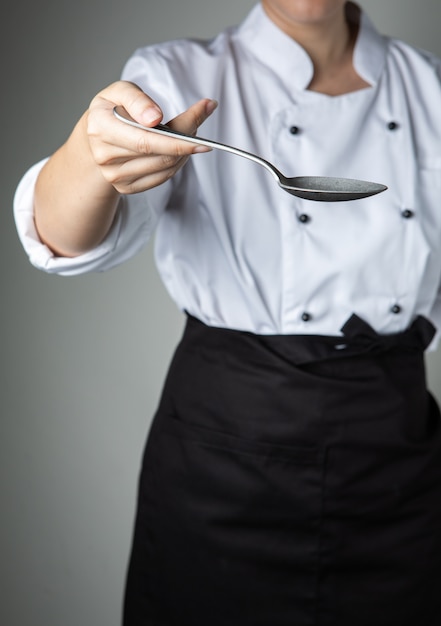 Colher de mão de chef cozinhar preparar comida no restaurante de cozinha quero que você tenha um sabor delicioso