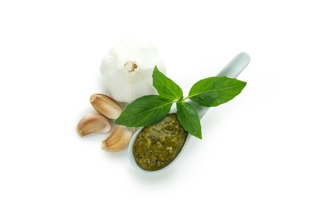 Colher de molho pesto e ingredientes isolados no fundo branco