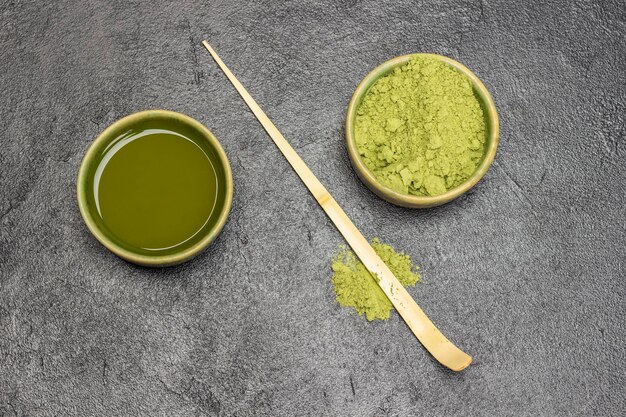 Colher medidora de bambu sobre a mesa Pó de chá matcha verde e chá matcha em tigelas verdes