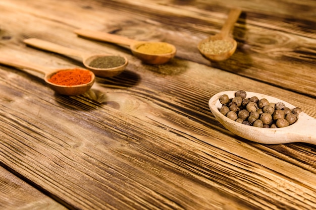 Colheres com os diferentes temperos na mesa de madeira