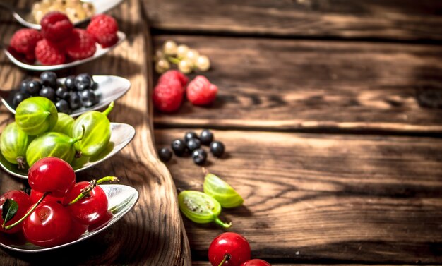 Colheres de frutas diferentes. Em uma mesa de madeira.