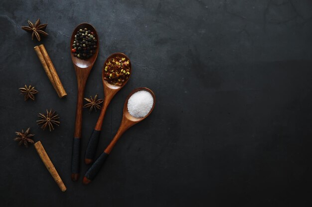 Colheres de pau com especiarias Uma mistura de pimentas e especiarias Ervas perfumadas para alimentos