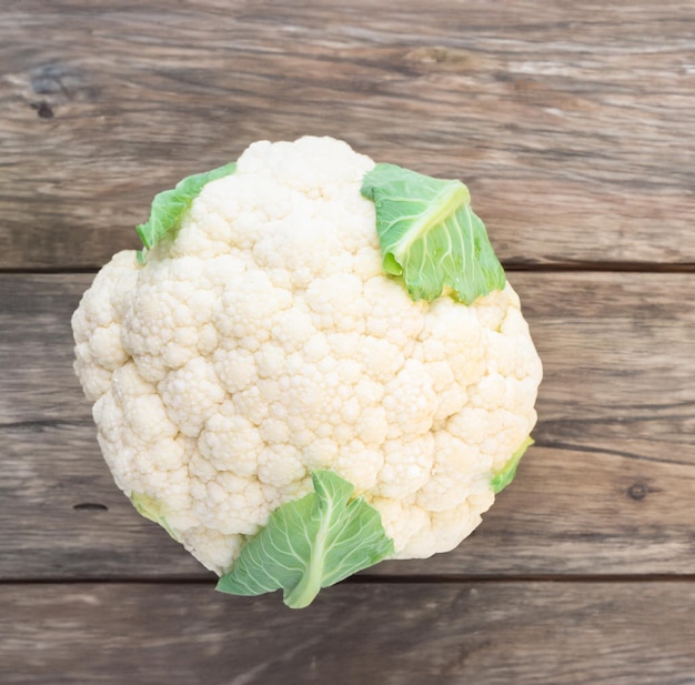 Coliflor blanca madura con hojas verdes vegetales orgánicos saludables sobre fondo blanco.