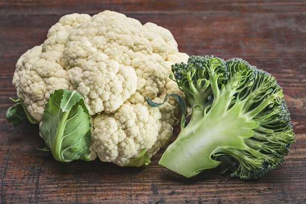 Coliflor y brócoli en mesa de madera antigua