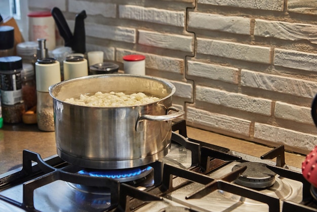 La coliflor se cocina en una cacerola en la estufa de gas